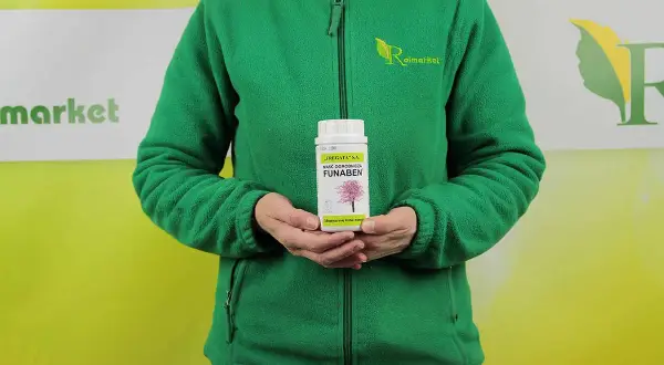 Osoba w zielonej bluzie trzyma maść ogrodniczą FUNABEN. Produkt przeznaczony do pielęgnacji drzew i krzewów.